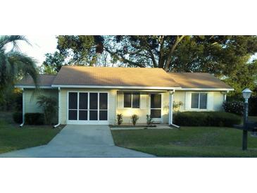 Charming single-story home with a neutral color, well-manicured lawn, and a screened in garage at 10891 Sw 86Th Ave, Ocala, FL 34481