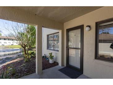 Inviting condo entrance featuring a well-lit doorway, small front garden, and views of the community's pond and landscaping at 1601 Big Tree Rd # 601, South Daytona, FL 32119