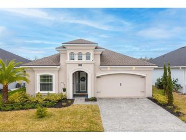 Charming single-story home with manicured lawn, stone accents, and a two-car garage on a sunny day at 604 Mosaic Blvd, Daytona Beach, FL 32124