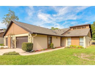 Inviting home featuring a well-manicured lawn, two-car garage, and complementary exterior paint at 206 Sage Brush Trl, Ormond Beach, FL 32174