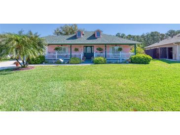 Charming single-Gathering home featuring a lush green lawn, a front porch, and lovely landscaping at 6172 Knotty Pine Ct, Port Orange, FL 32127