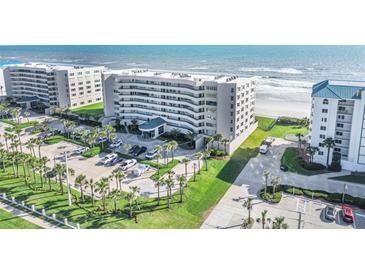 Stunning aerial view of a beachfront condo building with lush landscaping and private beach access at 4631 S Atlantic Ave # 8706, Ponce Inlet, FL 32127