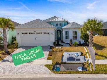 Beautiful single-Gathering home featuring solar panels, a two-car garage and tropical landscaping at 540 Good Life Way, Daytona Beach, FL 32124