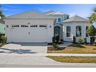 Charming single-Gathering home featuring a white exterior, two-car garage, and meticulously manicured landscaping at 540 Good Life Way, Daytona Beach, FL 32124