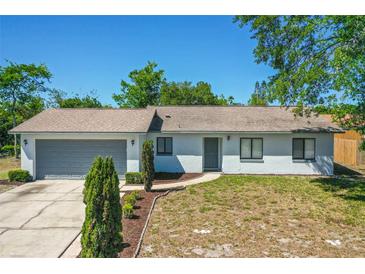 Charming single-story home featuring a neatly landscaped front yard and attached garage at 1197 Stillwood Ct, Port Orange, FL 32129