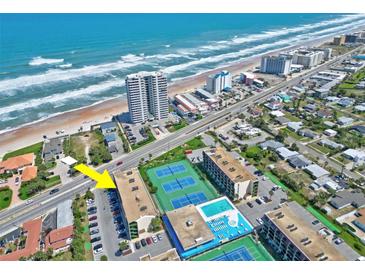 Stunning aerial view of the beachfront property with tennis courts and swimming pool and ample parking at 1441 N Atlantic Ave # 417, Daytona Beach, FL 32118