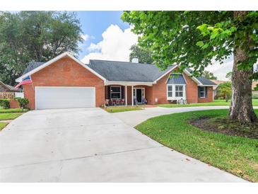 Charming single-story brick home with a two car garage, manicured lawn and inviting covered porch at 27 Winding Creek Way, Ormond Beach, FL 32174
