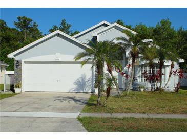 Charming single-story home with a two-car garage, palm trees, and well-maintained landscaping in a residential neighborhood at 8958 Fort Jefferson Blvd, Orlando, FL 32822
