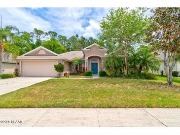 Charming single-story home with a well-maintained lawn, mature trees, and an attached two-car garage at 5313 Georgia Peach Ave, Port Orange, FL 32128