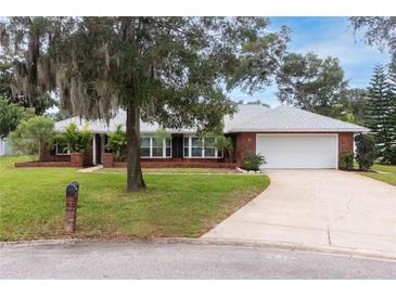 Charming single-story brick home featuring a well-manicured lawn and mature trees offering shade and curb appeal at 11 Larisa Ter, Ormond Beach, FL 32174