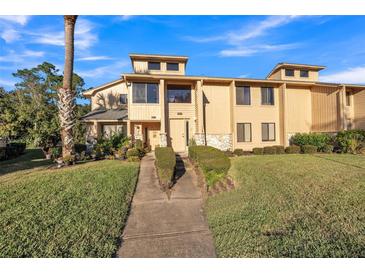 Inviting townhome with a well-manicured lawn and trimmed bushes lining the walkway at 133 Blue Heron Dr # C, Daytona Beach, FL 32119
