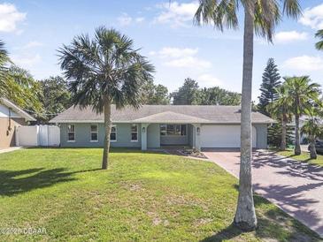 Charming single-story home with lush lawn and mature palms in a sunny, tropical setting at 44 Sandra Dr, Ormond Beach, FL 32176