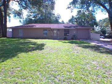 Charming one-story home with a well-maintained lawn and mature trees at 601 E Tall Pine Ter, Deland, FL 32724
