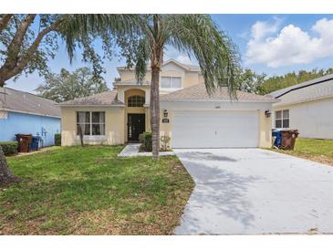Charming two-story home with a well-manicured lawn and a spacious two-car garage at 1305 Rebecca Dr, Haines City, FL 33844