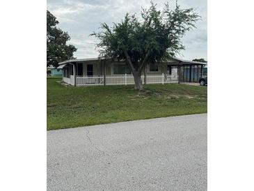 Charming home featuring a well-maintained front yard and inviting curb appeal with lovely green grass and mature trees at 9393 Sw 102Nd Pl, Ocala, FL 34481