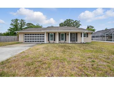 Charming single-story home featuring a unique garage door and well-maintained lawn at 290 Greenwood Cir, Ormond Beach, FL 32174