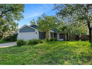 Charming one-story home with a light blue exterior and a well-manicured front lawn at 1317 Northside Dr, Ormond Beach, FL 32174