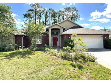 Charming single-story brick home with a well-manicured lawn and a bright red front door at 16 Hunt Master Ct, Ormond Beach, FL 32174