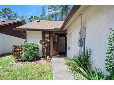 Inviting front entrance with well-maintained landscaping and a charming, light-colored exterior at 915 Stonybrook Cir, Port Orange, FL 32127