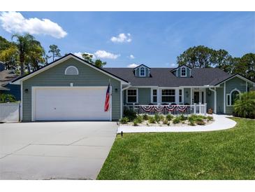 Charming single-story home with a spacious driveway, two-car garage, and a quaint front porch at 516 Spotted Sandpiper Dr, Daytona Beach, FL 32119