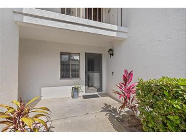 Welcoming entrance with a screen door, window, and beautiful plants at 1 Tomoka Oaks Blvd # 135, Ormond Beach, FL 32174