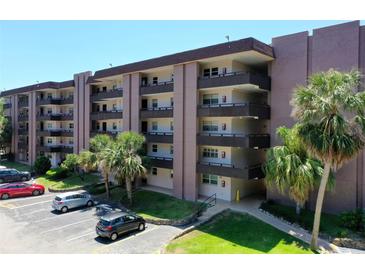 Exterior shot of condominium with parking, landscaping, and multi-story covered balconies at 640 N Nova Rd # 117, Ormond Beach, FL 32174