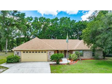 Charming one-story brick home featuring a well-manicured lawn and an attached two-car garage at 2270 Wilmhurst Rd, Deland, FL 32720