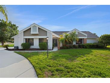 Charming single-story home with well-manicured lawn, mature landscaping, and inviting entrance at 101 Green Heron Ct, Daytona Beach, FL 32119