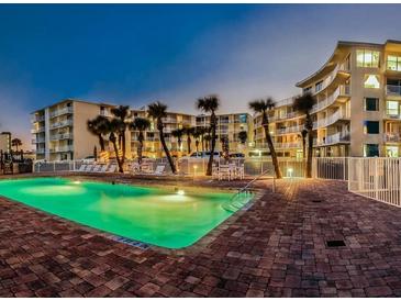Inviting pool area at dusk with palm trees and stylish condo buildings in the background at 1233 S Atlantic Ave # 3070, Daytona Beach, FL 32118