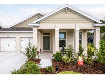 Charming home featuring a manicured lawn, covered porch, and a two-car garage, creating a welcoming curb appeal at 2861 Monaghan Dr, Ormond Beach, FL 32174