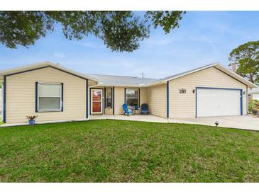 Charming single-story home with a well-maintained lawn and attached garage, accented by blue trim and a red front door at 2910 Yule Tree Dr, Edgewater, FL 32141