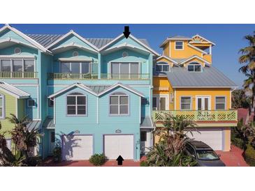 Charming blue and yellow townhomes with garages and balconies offer a coastal living experience at 3000 Ocean Shore Blvd # 18, Ormond Beach, FL 32176