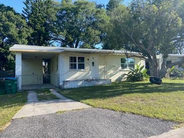 Charming single-story home featuring a carport, well-maintained lawn, and a mature tree providing ample shade at 264 Sherwood Ln, Daytona Beach, FL 32117