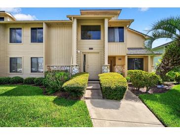 Inviting two-story condo with well-maintained landscaping and walkway leading to the front door at 133 Blue Heron Dr # D, Daytona Beach, FL 32119