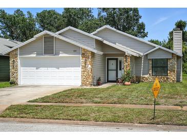 Charming single-Gathering home featuring stone accents, a well-manicured lawn, and an attached two-car garage at 920 N Lakewood Ter, Port Orange, FL 32127