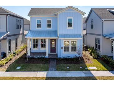 Charming two-story home with a covered porch, well-maintained lawn, and beautiful light blue exterior at 9762 Neruda St, Orlando, FL 32827