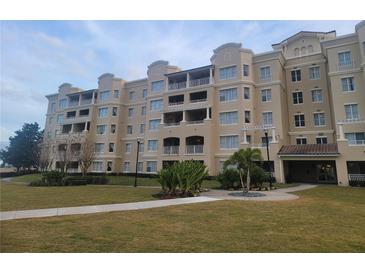 Tan multi-story building with balconies and landscaped grounds at 8495 Miracle Dr # 202, Champions Gate, FL 33896