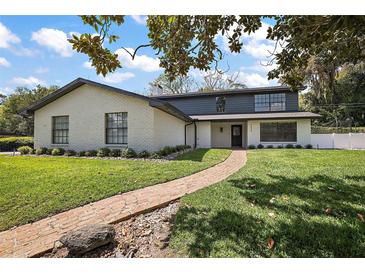 Charming two-story home with brick pathway, manicured lawn, and fresh white paint at 1635 Hilltop Dr, Mount Dora, FL 32757