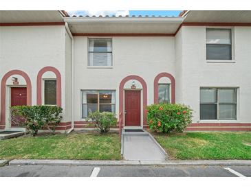 Inviting exterior of townhome with red door and well-manicured landscaping at 6299 River Run Pl # 198, Orlando, FL 32807