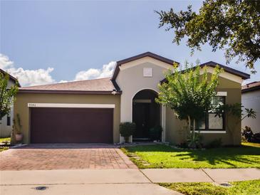 Charming single-story home with a two-car garage, a well-manicured lawn, and a brick-paved driveway at 9342 Oglethorpe Dr, Groveland, FL 34736