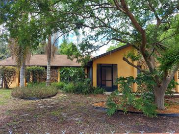 Charming one-story home featuring a stone accent wall, mature landscaping, and a screened front porch at 14700 Se 94Th Ave, Summerfield, FL 34491