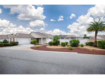 Charming single-story home featuring a well-manicured lawn and a welcoming front porch area at 3114 Jemima Ave, The Villages, FL 32163