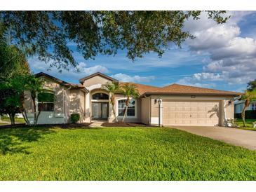 Beautiful home featuring a well-manicured lawn, two-car garage, and freshly painted exterior at 27303 Gingerbread Pl, Leesburg, FL 34748