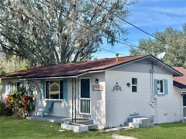 Charming ranch home with a red roof and landscaped lawn at 11635 Se Highway 42, Weirsdale, FL 32195