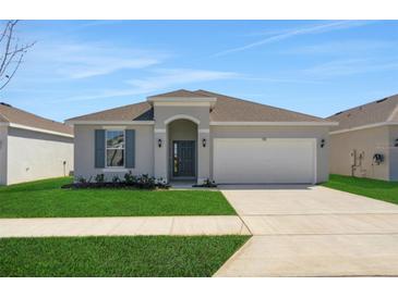 Charming single-story home features a well-manicured lawn and attached two-car garage at 191 Bottle Brush Dr, Haines City, FL 33844