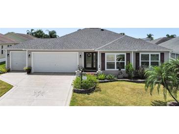 Charming single-story home with a two-car garage, well-manicured lawn, and inviting front entrance at 736 Jones Ln, The Villages, FL 32163