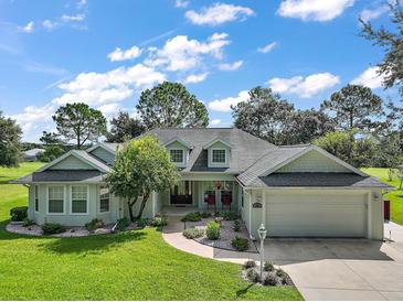 Charming single-story home with lush front yard, mature trees, and two-car garage at 557 Dowling Cir, Lady Lake, FL 32159
