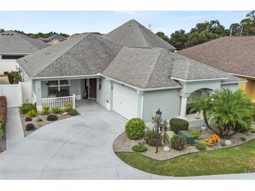Attractive single-Gathering home with a well-manicured lawn, gray roof, and a spacious driveway leading to a garage at 2968 Wotring Way, The Villages, FL 32163