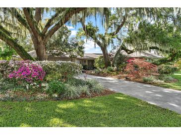 Beautiful home with lush landscaping, long driveway, and mature oak trees at 1785 Maine Ct, Tavares, FL 32778