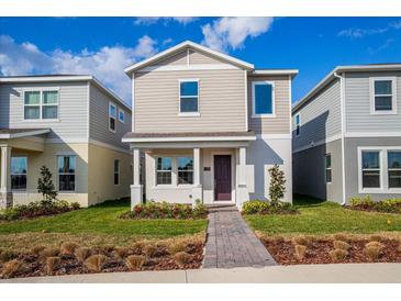 Two-story tan house with a purple door and landscaped lawn at 17036 Clear Mind Aly, Winter Garden, FL 34787